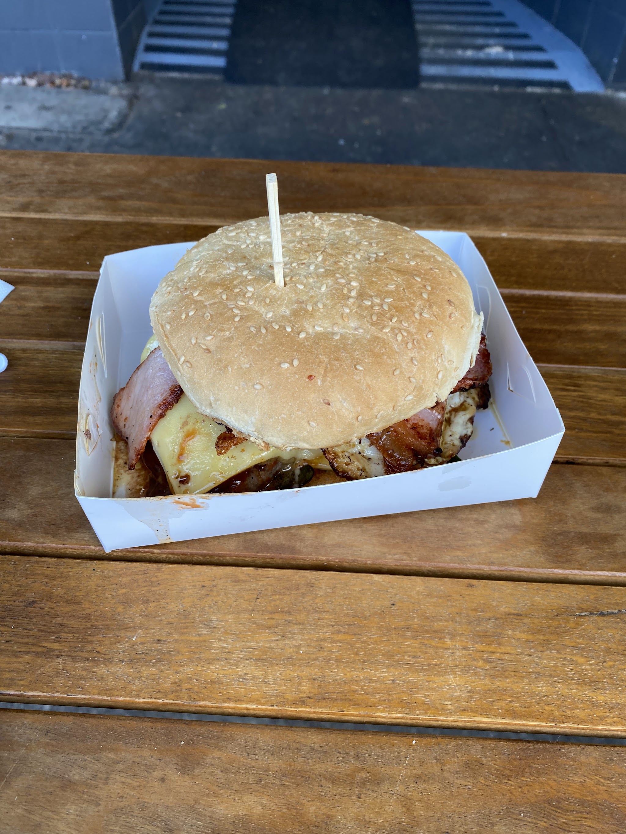 A burger in its box on the timber bench outside the shop